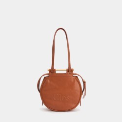 Crossbody bag on one shoulder with a top layer of calfskin commuter tote